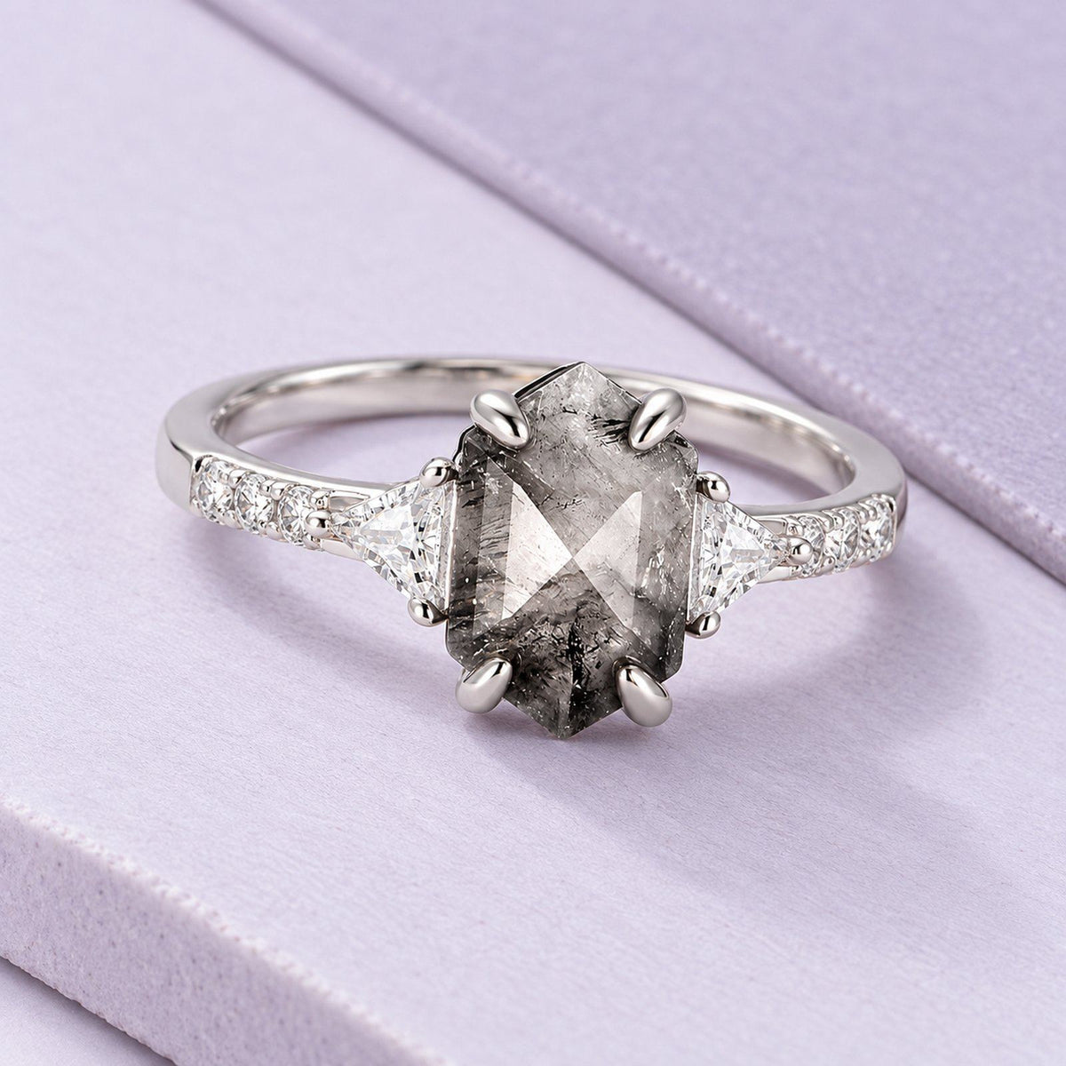 Silver hexagon Herkimer quartz ring with natural dark inclusions and triangular side stones on broad pale-lilac tiles.