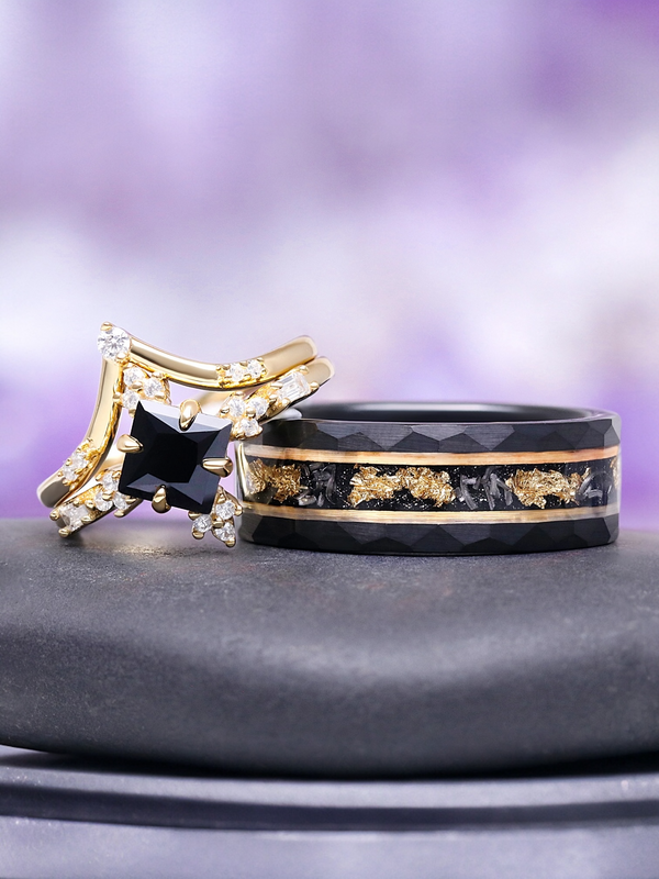 Two rings, one gold and black with a star-shaped gem, the other black with gold accents, on a gray surface with a purple gradient background.