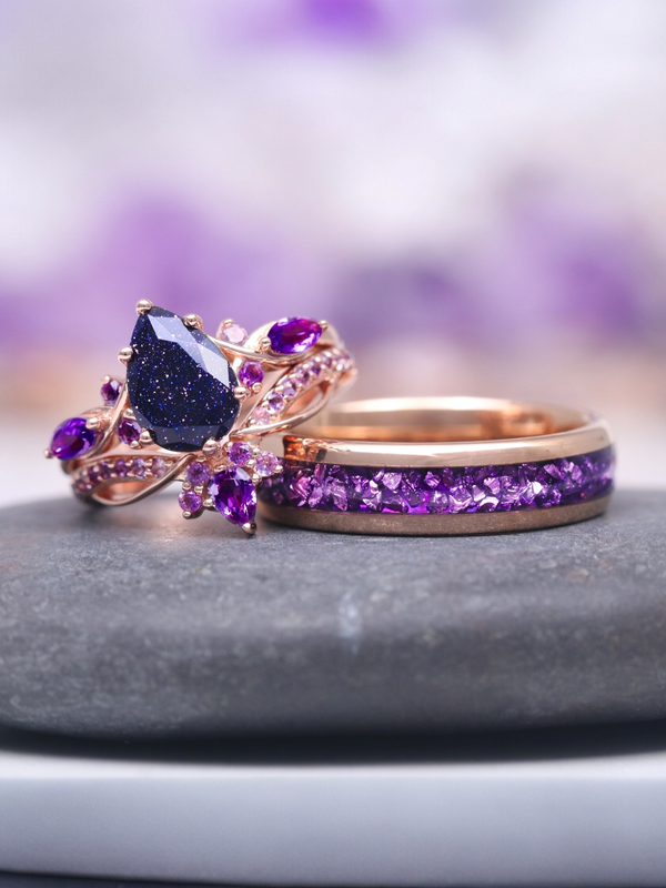Two purple gemstone rings on a gray surface with a blurred purple background