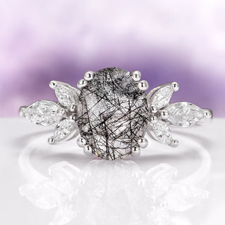 Oval black rutilated quartz ring in sterling silver, clear quartz crossed by fine black needles, flanked by marquise white accent stones