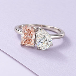 White-gold Toi Et Moi ring with a blush morganite and pear lab-grown diamond, photographed on a broad lilac paper sheet.