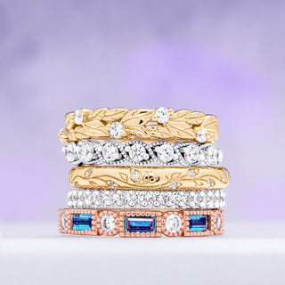 Stack of gold and silver Aquamarise wedding bands set with gemstones