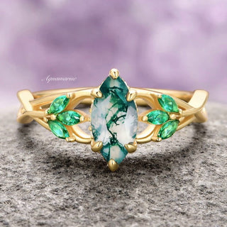 A marquise cut green moss agate ring with marquise cut emerald side stones, set in 14K yellow gold vermeil with twisted vine and Celtic knot design elements.