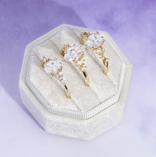 Gold and crystal jewelry set in a hexagonal white box on a light purple background