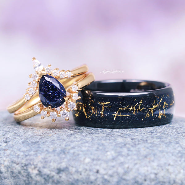 Starry Night Engagement Ring Set in 14K Solid Yellow Gold featuring a teardrop blue sandstone center surrounded by delicate diamonds, paired with a black band inlaid with gold flakes, crafted by Aquamarise Gold.