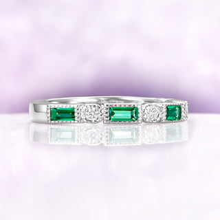 Art Deco Emerald Milgrain Wedding Band in Sterling Silver by Aquamarise featuring emerald-cut emeralds and round diamonds with detailed milgrain edges on a polished silver band.