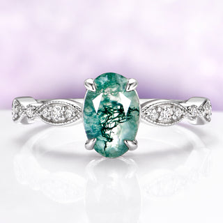 Ring with a green gemstone and diamond-studded band on a light purple background