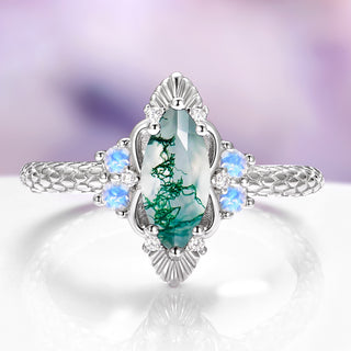 Silver ring with a green gemstone and smaller blue stones on a white background