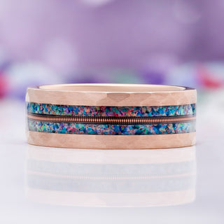 Close-up of the guitar string and blue fire opal inlay on hammered rose gold