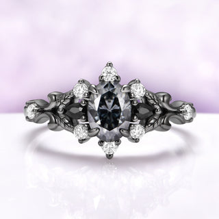Carmilla engagement ring in black ruthenium, oval gray moissanite between black onyx pears with carved leaf and vine shoulders