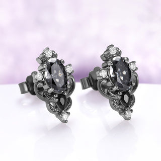Angled view of the Carmilla gray moissanite studs showing the butterfly push-backs and clear moissanite accents against the dark finish