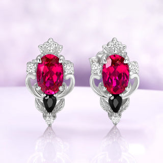 Carmilla lab-grown ruby stud earrings in sterling silver, oval centers with black onyx pears and carved leaf and scroll frames