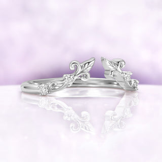 Angled view of the Carmilla ruby set enhancer band showing the open front and carved leaf terminals