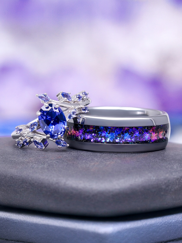 Two rings with colorful gemstones on a gray surface with a blurred purple background