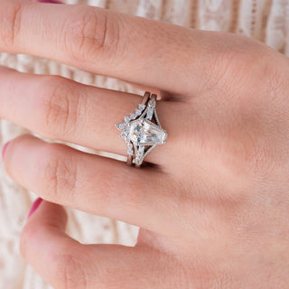 White gold engagement ring set with coffin cut diamond center stone and accents on hand over a light background 