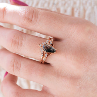 Rose gold engagement ring set with coffin cut Herkimer diamond center stone and accents on hand over a light background 