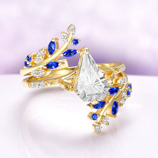 Blue Sapphire & Fantasy Shield Cut Diamond Couples Ring Set by Aquamarise featuring yellow gold bands with marquise blue sapphires and shield-cut diamond CZ in a nature-inspired design.