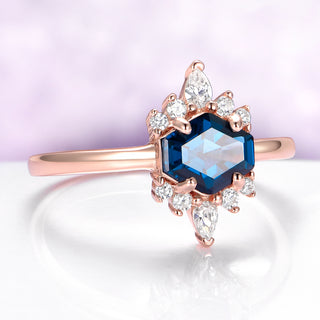 Rose gold ring with a blue gemstone and diamonds on a light purple background