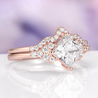 Rose gold ring with a large diamond and smaller diamonds on a soft purple background