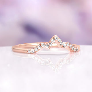 Rose gold ring with diamonds on a soft purple background