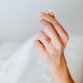 Hand with a diamond ring on a light background