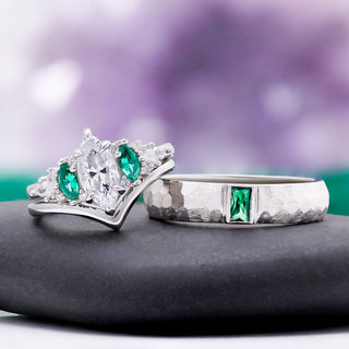 Emerie Diamond & Emerald Couple Ring by Aquamarise, the engagement ring and hammered emerald band shown on a grey stone pedestal.