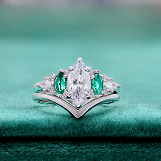 Emerie Diamond & Emerald Engagement Ring by Aquamarise, displayed on green velvet with the marquise diamond centre.