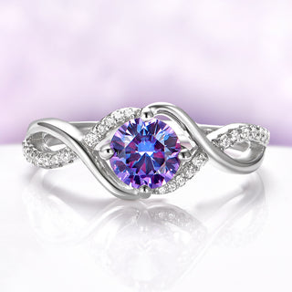 Entwined Alexandrite Ring in Sterling Silver by Aquamarise, featuring a round color-change stone with a twisting band accented by sparkling pavé crystals in a modern, elegant design.