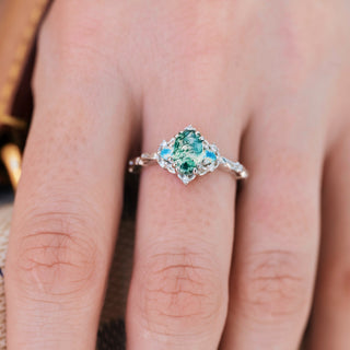 White gold ring with natural moss agate center stone and opalescent sapphire accents on hand 