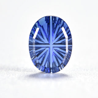 Faelight Cut lab-grown blue sapphire oval 6 x 8 mm loose gemstone, concave starburst facets, on white