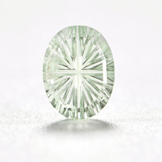 Faelight Cut lab-grown green sapphire oval 6 x 8 mm loose gemstone, concave starburst facets, on white