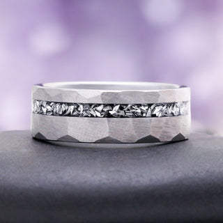 Hammered silver tungsten band on slate, showing the light-catching crushed meteorite channel