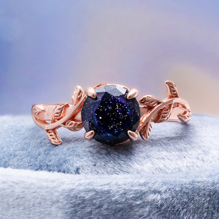 Close-up of the six-prong setting and leaf detailing around the blue goldstone center stone