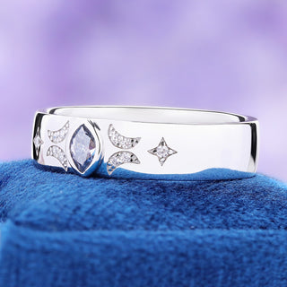 Angled view of the 6mm gray moissanite celestial band on blue velvet, showing the dome profile and star accents