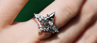 Star-shaped diamond ring on a finger with a green leaf background