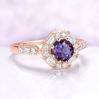 Rose gold ring with a purple gemstone and diamond accents on a light purple background