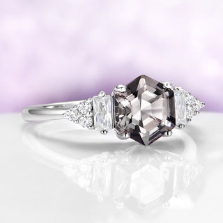 Diamond ring with a central brown diamond and triangular side stones on a white background