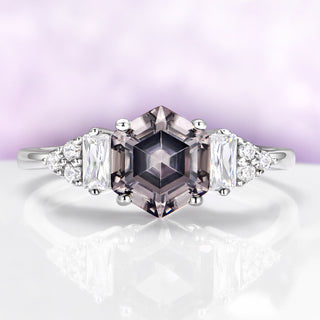 Diamond ring with a central pink diamond and two side stones on a light purple background