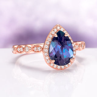 Art Deco Alexandrite Ring in 14K Rose Gold Vermeil by Aquamarise featuring a pear-shaped deep blue-violet gemstone surrounded by sparkling diamonds on a detailed rose gold band.