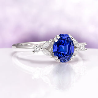 Oval Cut Blue Sapphire Engagement Ring in Sterling Silver featuring a vivid blue oval sapphire with marquise and round diamond accents on a polished band by Aquamarise.