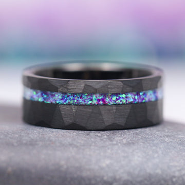 Lavender Fire Opal & Emerald Leaf Couples Ring Set by Aquamarise, featuring a black finish band with a hammered texture and a striking inlay of iridescent lavender fire opal and emerald hues, part of Matching Couples' Rings and Fantasy-Inspired Couples Rings collections.