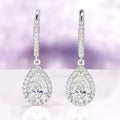 Vera Teardrop White Sapphire Drop Earrings in Sterling Silver by Aquamarise featuring teardrop white sapphire surrounded by sparkling accents for an elegant and timeless look.