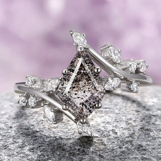 A sterling silver ring featuring a kite-cut Herkimer diamond with salt and pepper inclusions, accompanied by smaller clear stones on the band.