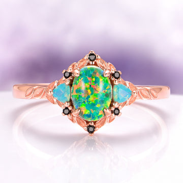 Green Fire Opal Leaf Engagement Ring in 14K Rose Gold Vermeil featuring a vibrant green fire opal center, opalescent side stones, and intricate leaf engraving by Aquamarise.