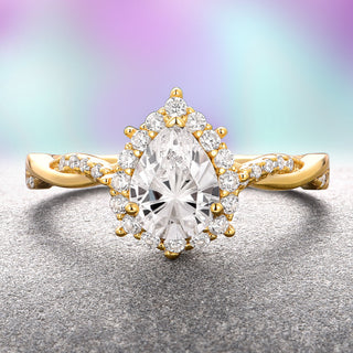 A lab-grown diamond engagement ring with a Fantasy Star Cut pear-shaped center stone in 14K solid yellow gold, displayed on a grey and purple background.