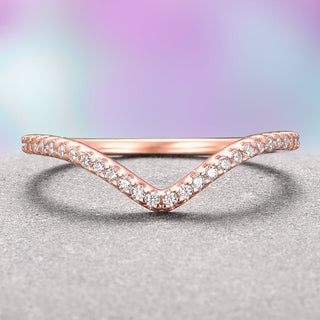A V-shaped wedding band made of 14K solid rose gold, featuring petite moissanite stones set along the arc of the band.