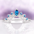 London Blue Topaz Stacking Wedding Band in Sterling Silver by Aquamarise, featuring marquise and round blue topaz stones with sparkling clear accents on a sleek curved band design.