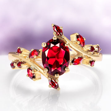 Natural Red Garnet Leaf Engagement Ring in 14K Solid Yellow Gold featuring a vibrant oval garnet surrounded by smaller garnets in a delicate leaf-inspired design by Aquamarise Gold.