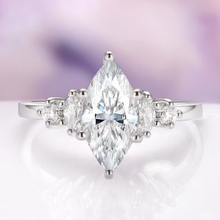 Diamond ring with a marquise-shaped center stone on a soft, blurred background