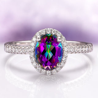 Ring with a colorful gemstone and diamond-studded halo on a light purple background